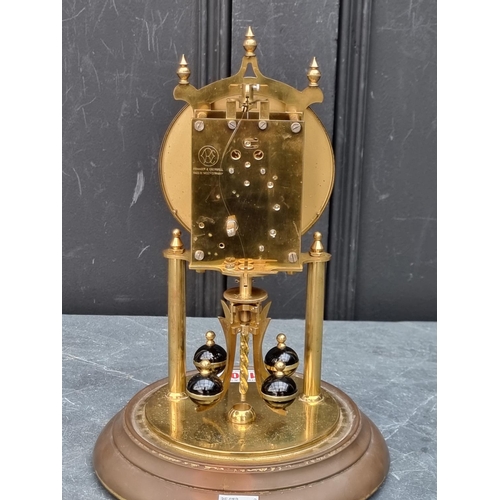 1106 - A brass anniversary clock, with glass dome, 29cm high.