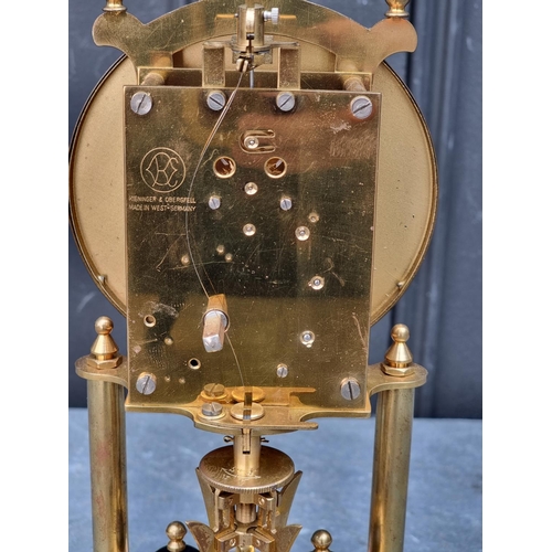 1106 - A brass anniversary clock, with glass dome, 29cm high.