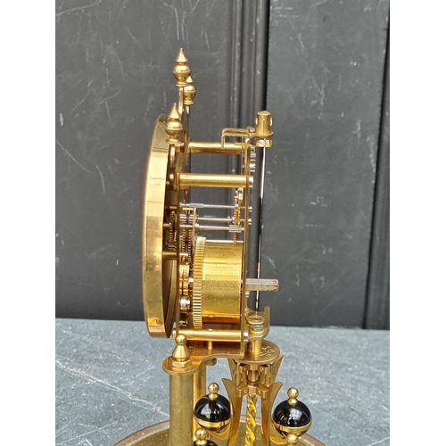 1106 - A brass anniversary clock, with glass dome, 29cm high.