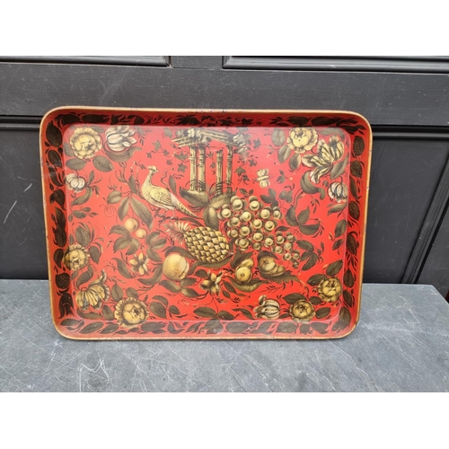 1110 - A good graduated pair of 19th century papier mache trays, with gilt decoration on a scarlet red grou... 