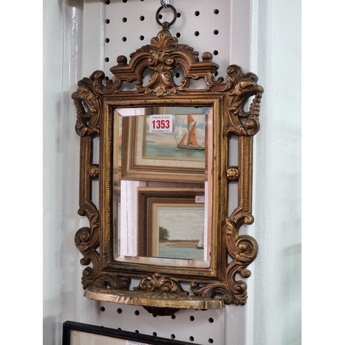 1353 - A Victorian gilt painted cast iron framed wall mirror, with apron shelf, 36 x 25cm.