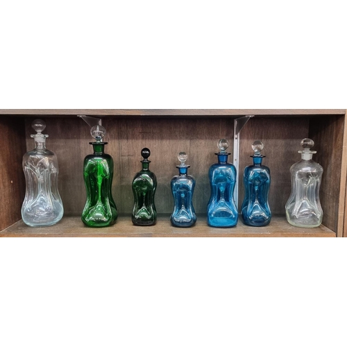 1496 - Seven glass 'glug glug' decanters and stoppers, largest 33cm high.