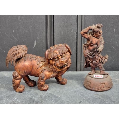 1523 - A Chinese carved giltwood lion dog, 23.5cm long; together with another Chinese carved giltwood figur... 