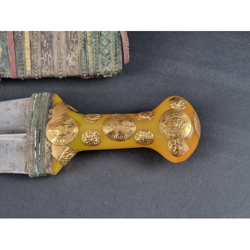 511 - An Arab jambiya and sheath, the 20cm blade with central ridge, yellow metal mounted plastic hilt, wi... 