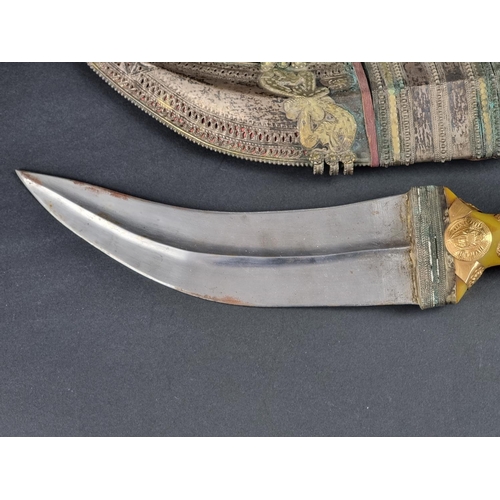 511 - An Arab jambiya and sheath, the 20cm blade with central ridge, yellow metal mounted plastic hilt, wi... 