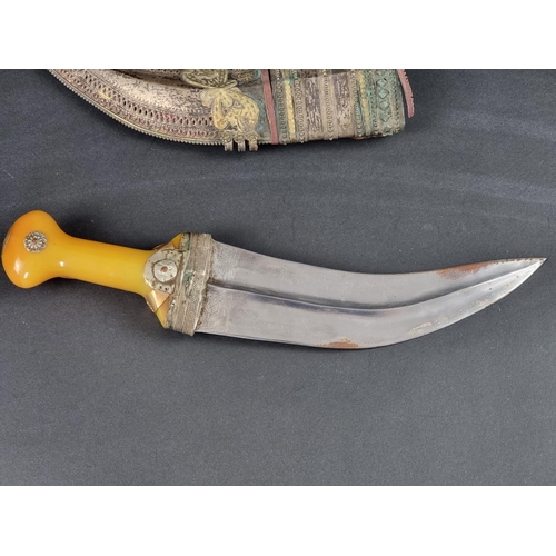 511 - An Arab jambiya and sheath, the 20cm blade with central ridge, yellow metal mounted plastic hilt, wi... 