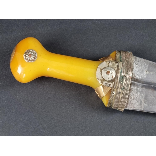 511 - An Arab jambiya and sheath, the 20cm blade with central ridge, yellow metal mounted plastic hilt, wi... 