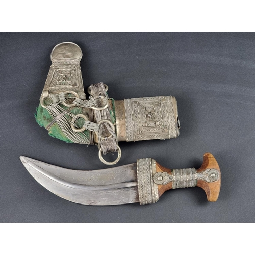 512 - A 20th century Omani seven ring metal clad jambiya, with wooden hilt, having 17cm blade.... 