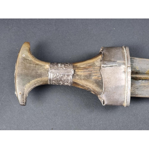 513 - A late 19th/early 20th century Omani four-ringed silver mounted jambiya, with horn hilt, having 17cm... 