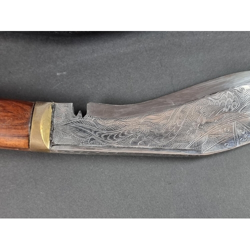 521 - A kukri and scabbard, with 22cm chased blade; together with another similar example. (2)... 