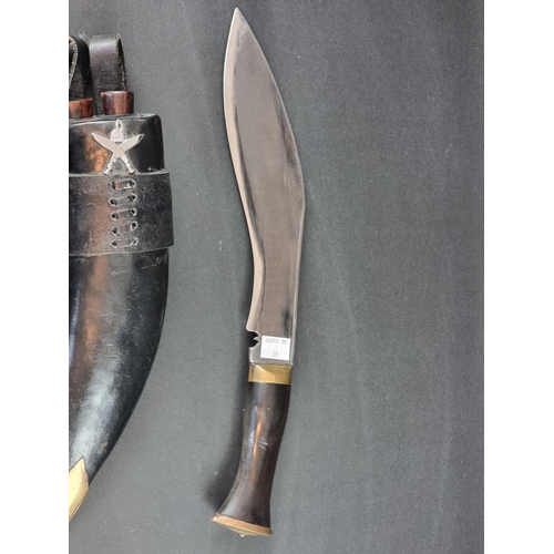 522 - A kukri and scabbard, the 16cm curved blade stamped 'Gorkha Army 3032'.