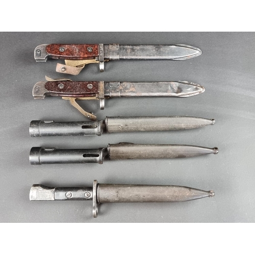 524 - Five modern bayonets and scabbards; to include two FN Fal tube bayonets.