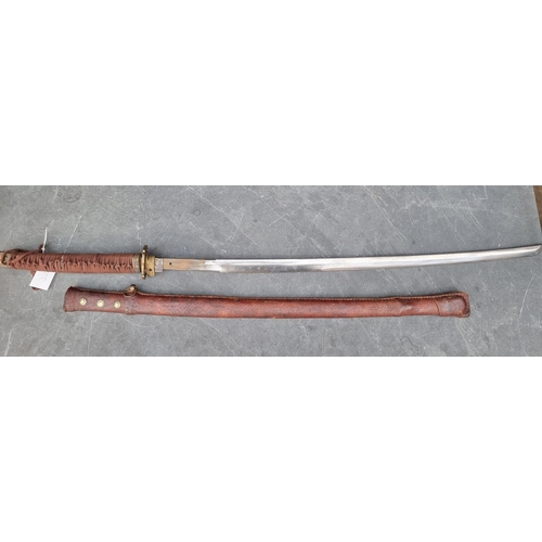 554 - A reproduction Japanese katana and scabbard, having 69cm Damascus blade, overall length 103cm.... 