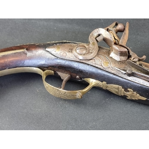 564 - An 18th century brass mounted flintlock pistol, possibly Spanish, with some residual silver plating,... 