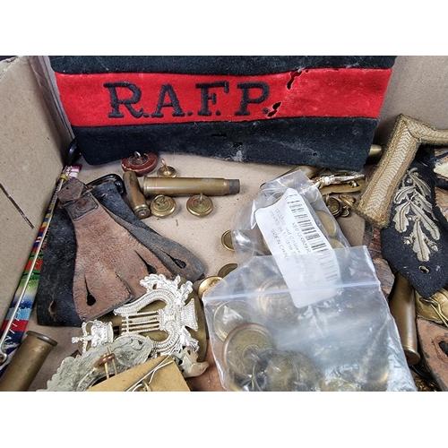 726 - A quantity of military cap badges, buttons, empty bullet cases etc.