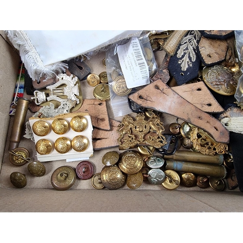 726 - A quantity of military cap badges, buttons, empty bullet cases etc.