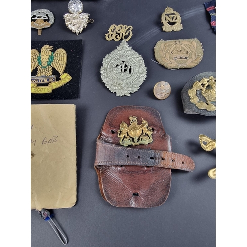 727 - A small collection of British military cap badges, buttons and similar.