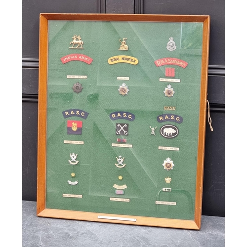 777 - A mounted group of Insignia, for the R.M.A Sandhurst, Indian Army Royal Norfolk Regiment and R.A.S.C... 