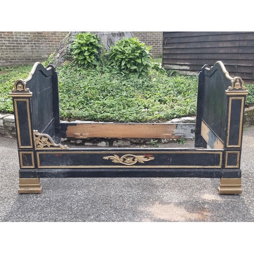 1083 - An antique continental ebonised and parcel gilt day bed, 131cm wide.