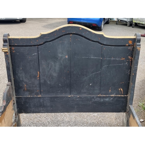 1083 - An antique continental ebonised and parcel gilt day bed, 131cm wide.