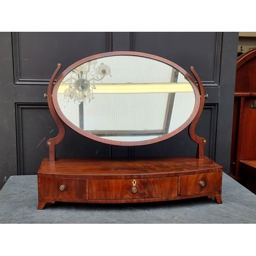 1034 - A large early 19th century mahogany and crossbanded toilet mirror, with bone escutcheon, 79cm wide.... 