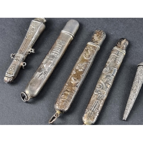 160 - Four white metal pendant bodkin cases, stamped 'Sterling'; together with another similar bodkin case... 