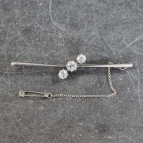 230 - A white metal diamond three stone bar brooch, set graduated brilliant cut stones, totalling approxim... 