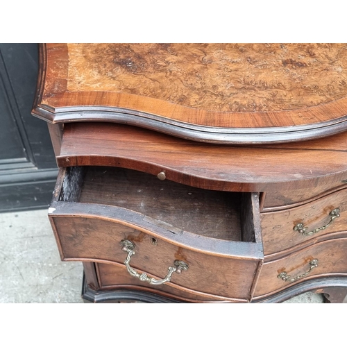 1008 - A 1930s burr walnut and crossbanded serpentine fronted chest of drawers, with brushing slide, 71cm w... 