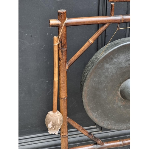 1009 - An old bamboo gong stand, total width 62.5cm, with beater.