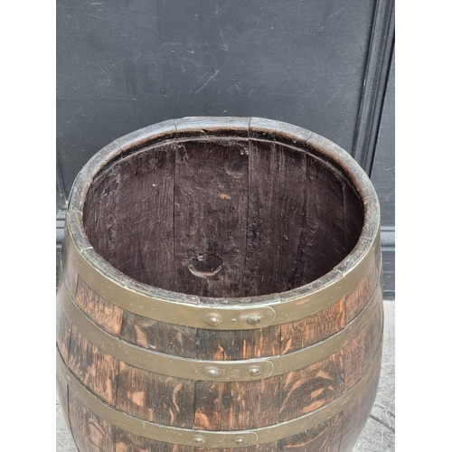 1019 - An old oak and coopered brass barrel, 61cm high.