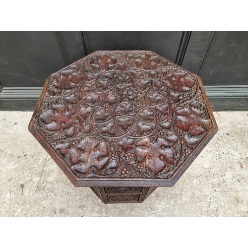 1028 - An Eastern carved and pierced hardwood octagonal folding table, 60cm wide.