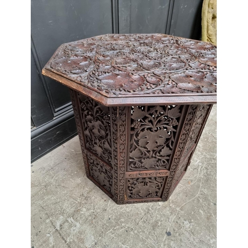 1028 - An Eastern carved and pierced hardwood octagonal folding table, 60cm wide.