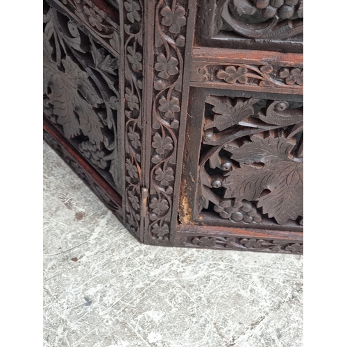 1028 - An Eastern carved and pierced hardwood octagonal folding table, 60cm wide.