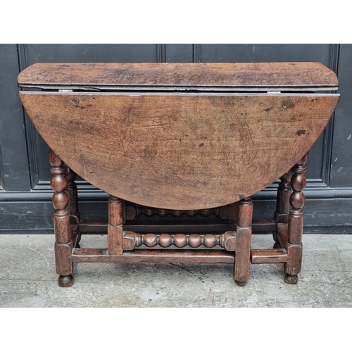 1049 - A circa 1700 oak gateleg table, with bobbin turned supports, 96.5cm wide.