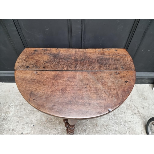 1049 - A circa 1700 oak gateleg table, with bobbin turned supports, 96.5cm wide.