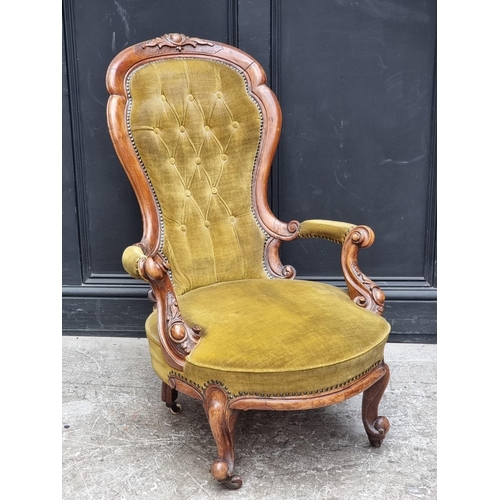 1071 - A Victorian carved walnut and button upholstered open arm occasional chair.