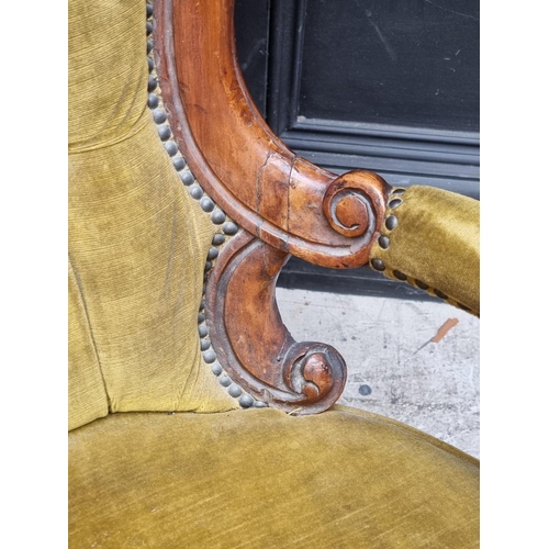 1071 - A Victorian carved walnut and button upholstered open arm occasional chair.