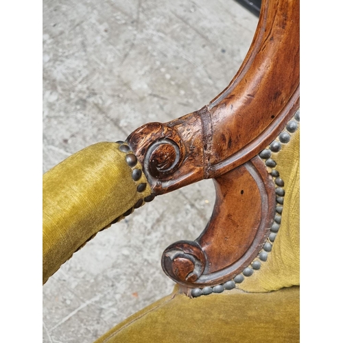 1071 - A Victorian carved walnut and button upholstered open arm occasional chair.