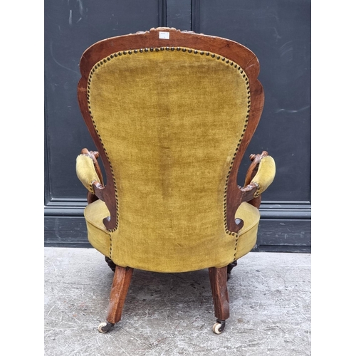 1071 - A Victorian carved walnut and button upholstered open arm occasional chair.