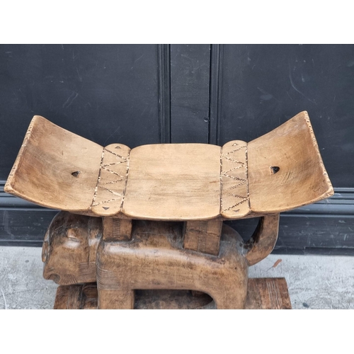 1094 - Ethnographica: an African animal form carved wood stool, probably Ashanti, 64cm wide.... 