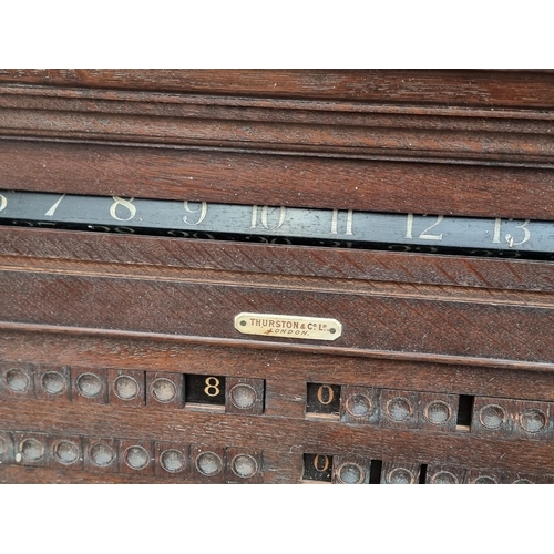 1095 - An early 20th century oak snooker score board, labelled 'Thurston & Co LD', with ivory markers, ... 