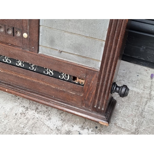 1095 - An early 20th century oak snooker score board, labelled 'Thurston & Co LD', with ivory markers, ... 