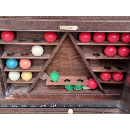 1095 - An early 20th century oak snooker score board, labelled 'Thurston & Co LD', with ivory markers, ... 