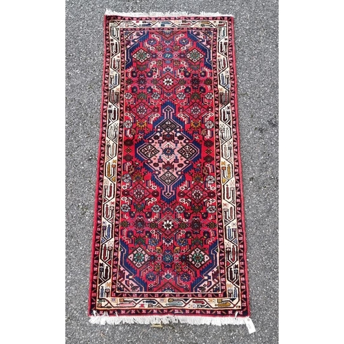 1131 - A Persian runner, having central diamond medallion, with geometric borders, 198 x 80cm.... 