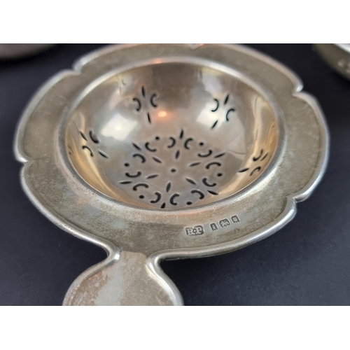 171 - A silver tea strainer, by Robert Pringle & Sons, London 1924, 10.5cm wide; together with tw... 