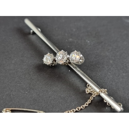 230 - A white metal diamond three stone bar brooch, set graduated brilliant cut stones, totalling approxim... 