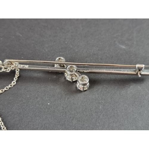 230 - A white metal diamond three stone bar brooch, set graduated brilliant cut stones, totalling approxim... 