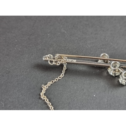 230 - A white metal diamond three stone bar brooch, set graduated brilliant cut stones, totalling approxim... 