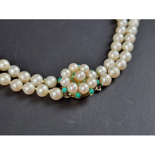 232 - A cultured pearl two strand necklace, the pearls of uniform size and fastened by a 9ct gold circular... 