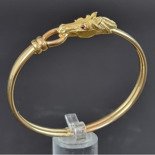 233 - A Gay Frères bangle, decorated stylised horse head with faceted ruby set eyes, having stamped maker'... 